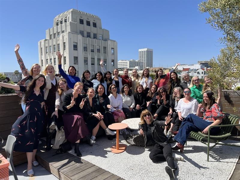 A group of women at a rooftop terrace on a sunny day.